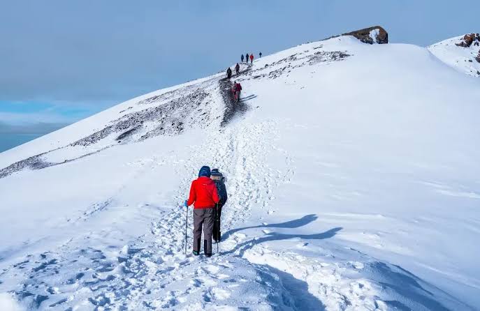 Climbers following a snowy mountain trail